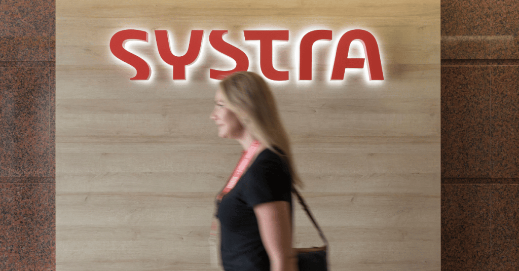 Woman walking past systra logo