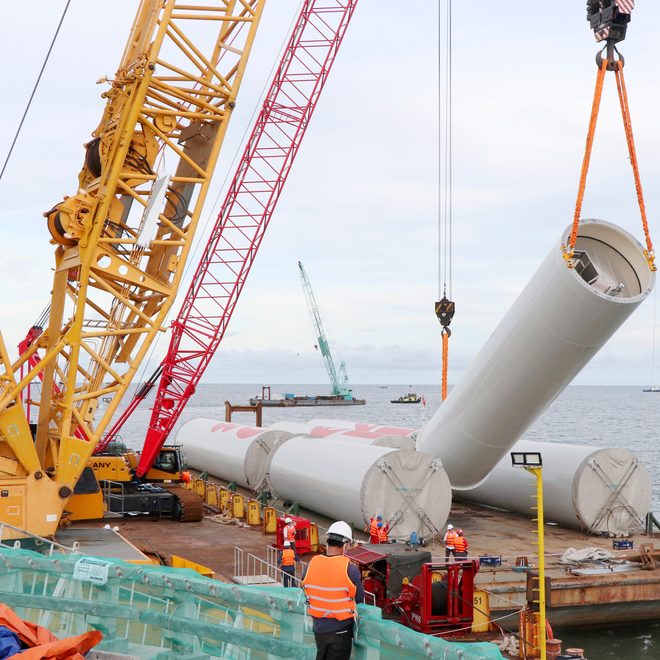 Crew lifting a wind turbine tower section
