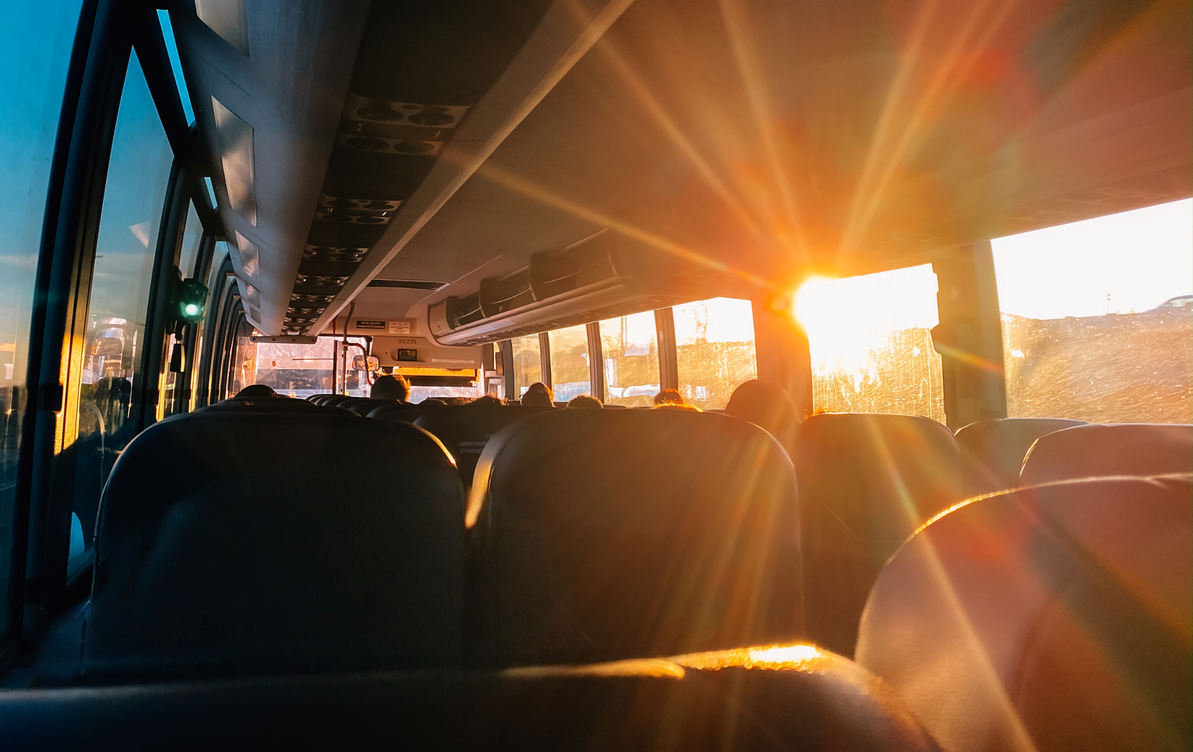 Bus trip, passengers on a bus with sun shining through window